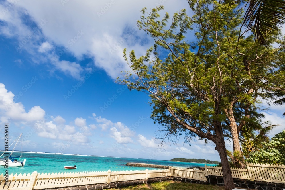 Tropical Coastal View with White Fence and Green Trees, Mauritius Tropical Coastal View with White Fence and Green Trees, Mauritius