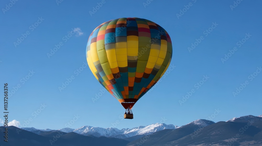 Obraz premium Colorful Hot Air Balloon Soaring Over Snowy Mountains