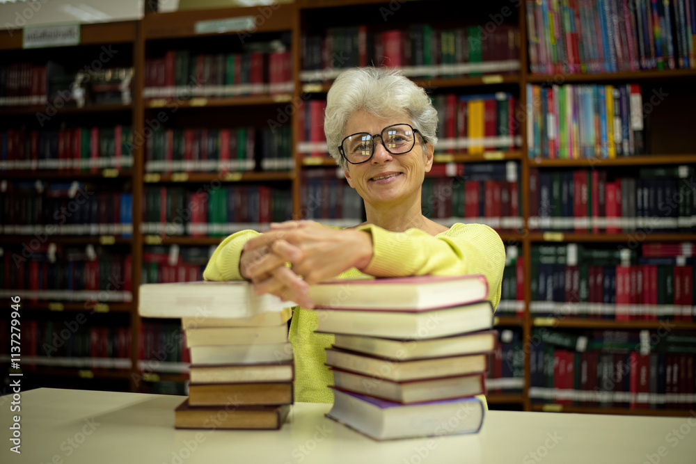 Elder woman sitting enjoys reading book in quiet of the library appears focused and content books with the idea of self-growth and discovery at any stage of life. Elder woman sitting enjoys reading book in quiet of the library appears focused and content books with the idea of self-growth and discovery at any stage of life.