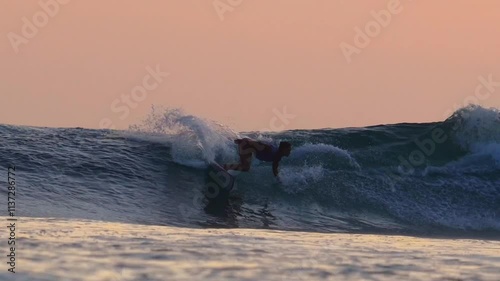 Female surfer on a wave at sunset time at Indian Ocean. High quality 4k footage