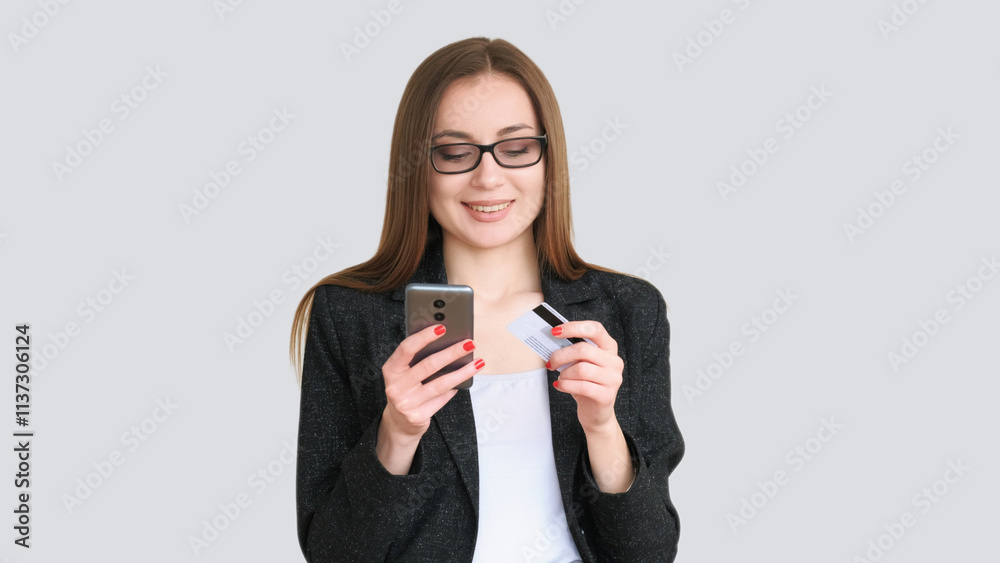 Internet banking. Cashless payment. Smiling business woman in glasses black blazer using mobile credit card isolated on gray copy space background. Internet banking. Cashless payment. Smiling business woman in glasses black blazer using mobile credit card isolated on gray copy space background.