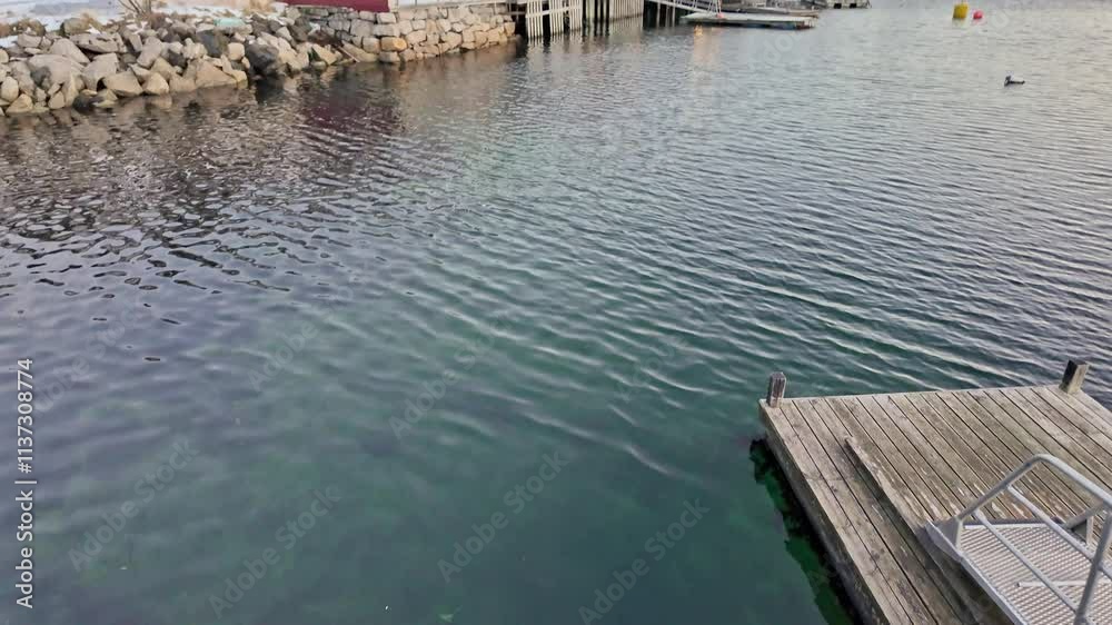Peaceful Nordic waters against a wooden dock in Svolvaer, Norway. Calm ambiance Peaceful Nordic waters against a wooden dock in Svolvaer, Norway. Calm ambiance