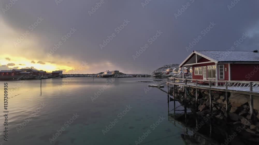 Scenic winter sunrise over calm waters in Lofoten, Norway, featuring cozy cabin Scenic winter sunrise over calm waters in Lofoten, Norway, featuring cozy cabin