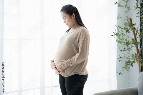 Pregnant asian woman holds hands on belly touching her baby caring about her health Beautiful happy pregnant woman tender mood photo of pregnancy. Free Download Pregnant asian woman holds hands on belly touching her baby caring about her health Beautiful happy pregnant woman tender mood photo of pregnancy. - GFXLoad