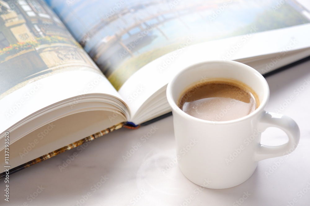 テーブルの上の開いた本(洋書)と、コーヒーの入ったコーヒーカップで、コーヒーを飲みながらゆっくりと読書を楽しんでいるイメージ
テーブルの上の開いた本(洋書)と、コーヒーの入ったコーヒーカップで、コーヒーを飲みながらゆっくりと読書を楽しんでいるイメージ