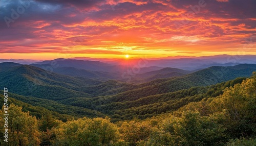 A breathtaking sunset over rolling mountains and lush green valleys.