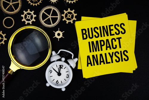 BIA - Business Impact Analysis text message on sticky note with magnifying glass and alarm clock on black background photo