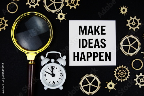 Make Ideas Happen text message on sticky note with magnifying glass and alarm clock on black background