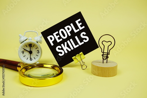 People Skills text message on sticky note with magnifying glass and alarm clock on yellow background