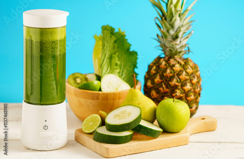 Generated imageGreen smoothie in a portable blender with cucumber, pineapple, and fresh fruits on a wooden table against a blue background. photo