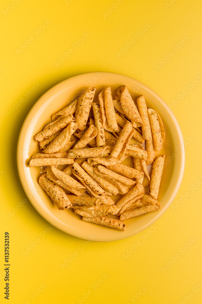 Rolled nachos tortilla chips on plate on yellow background. Top view. Rolled nachos tortilla chips on plate on yellow background. Top view.