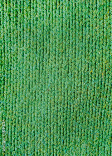 green knitted Wool fabric photographed close-up in a special design. Texture stands out with material. Clothing background sweater