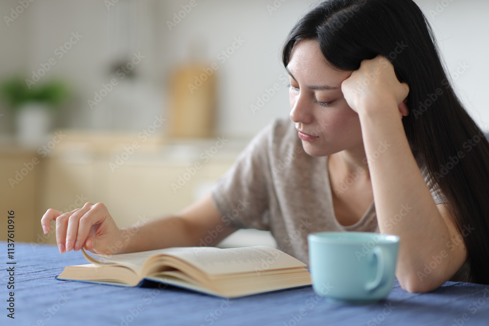 Concentrated asian woman reading a paper book Concentrated asian woman reading a paper book