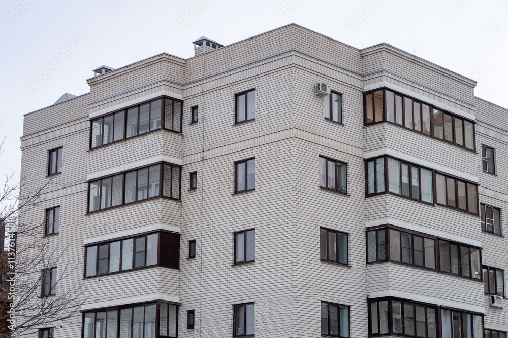 A large brick building with many windows and a metal air conditioner on the roof A large brick building with many windows and a metal air conditioner on the roof