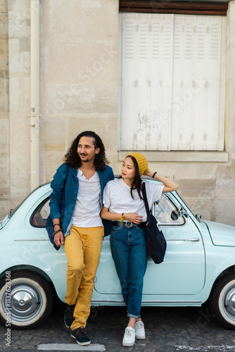 Young couple standing at small car