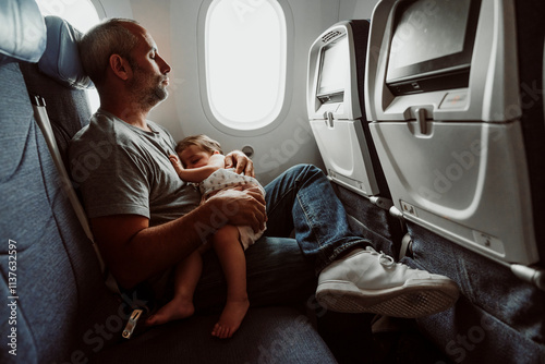 Father and daughter sleeping in airplane photo