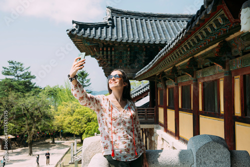 South Korea, Gyeongju, happy woman taking a selfie with cell phone in Bulguksa Temple photo