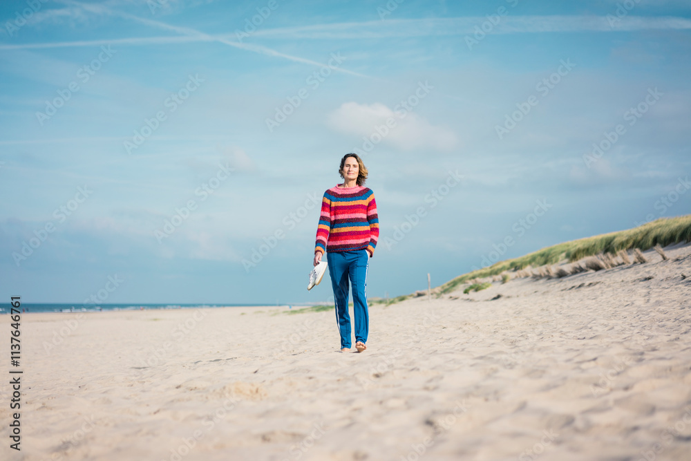 Mature woman walking barefoot on the beach Mature woman walking barefoot on the beach