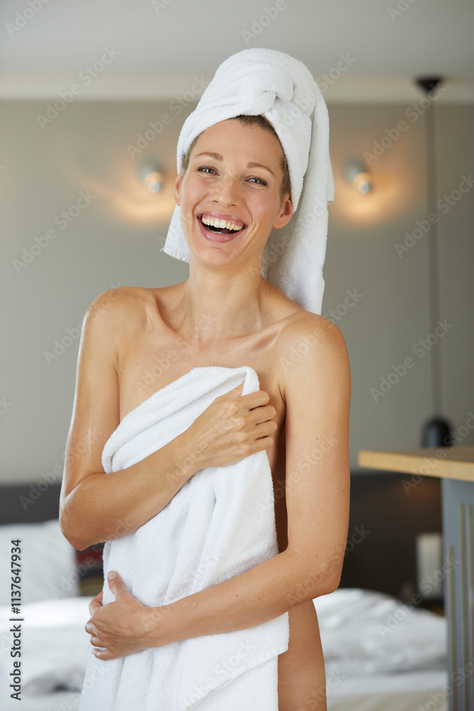 Portrait of laughing woman wrapped in towel standing in bedroom Portrait of laughing woman wrapped in towel standing in bedroom