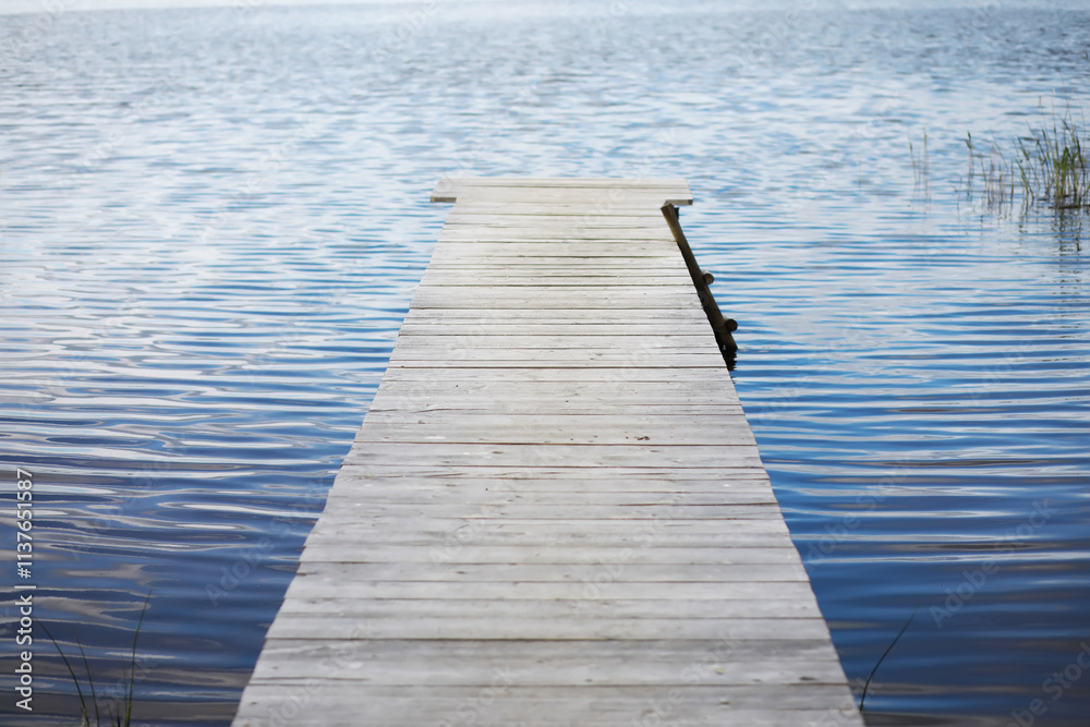 Serene Wooden Dock Extending over Calm Lake Waters in Peaceful Nature Setting Serene Wooden Dock Extending over Calm Lake Waters in Peaceful Nature Setting