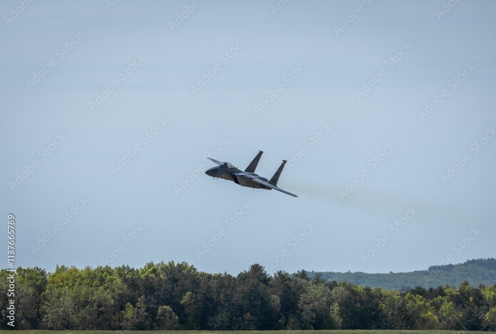 Fighter jet soaring over green forest Fighter jet soaring over green forest