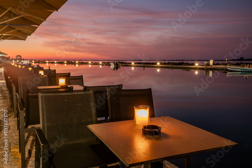 Obraz na płótnie Rows of tables illuminated by candlelight in a lantern at a restaurant on the seaside boulevard w salonie
