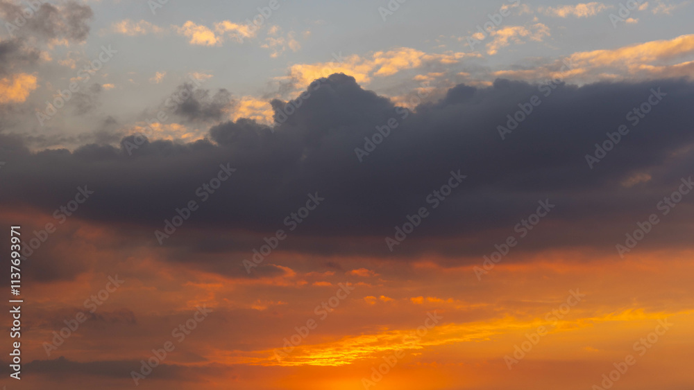 Obraz premium Beautiful sunset or sunrise sky, nature background. The beautiful clear sky was painted with bright golden shades by the sunlight.