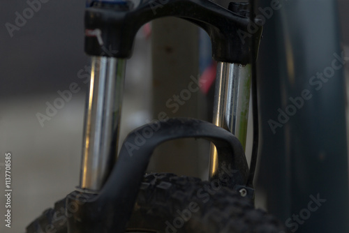 This image provides a closeup view of a bicycle fork featuring a tire attached to it, showcasing the details of the bicycles structure photo