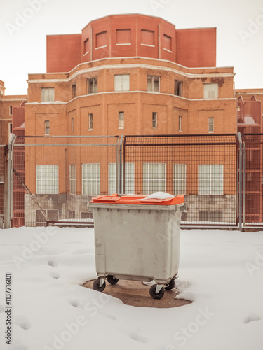 Urban winter scene with snow-covered dumpster photo