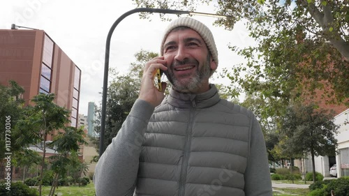 Joyful man engaging in a lively phone conversation while strolling outdoors