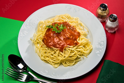 Plato de espaguetis con salsa de tomate y perejil en plato blanco. photo