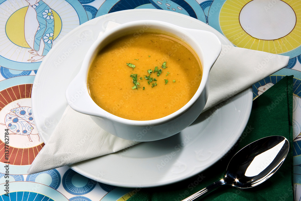 Sopa cremosa servida en bol blanco con decoración de perejil. Sopa cremosa servida en bol blanco con decoración de perejil.