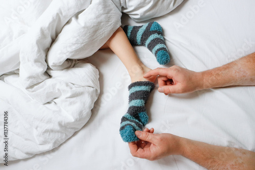 Foto Playful tickling of baby’s foot by dad in bed
