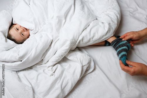 Gentle parenting moment removing sock from toddler
 photo