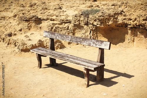 A lonely wooden bench on the seaside. Old bench in Cape Capo Greco.