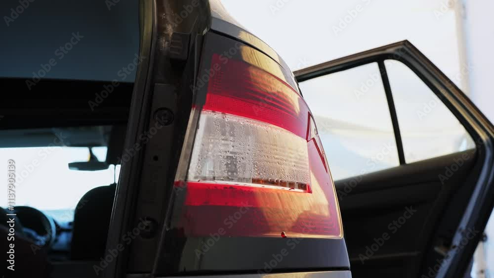 Close up of a back light of a car, vehicle, condensation drops inside the light, open door, static, car service repair