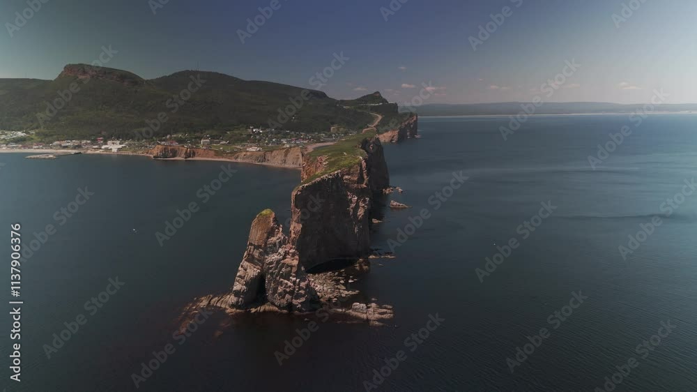 An aerial drone shot rotating around the famous Rocher Percé in Gaspésie. During summertime.