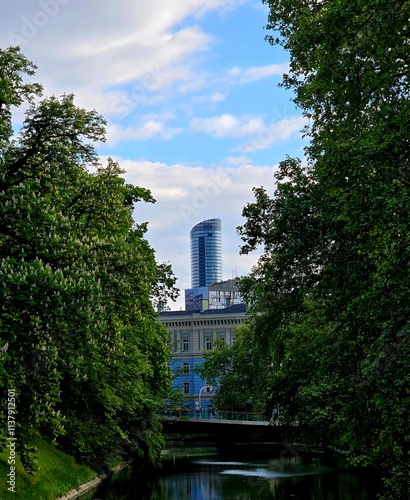 Widok na fosę miejską spokój odblask zielone drzewa w tle budynek sky tower wrocław  photo