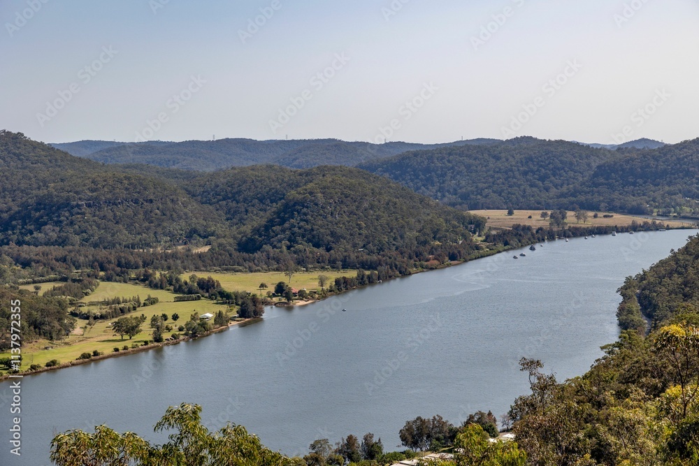 Scenic river and lush green hills under a clear sky. Scenic river and lush green hills under a clear sky.
