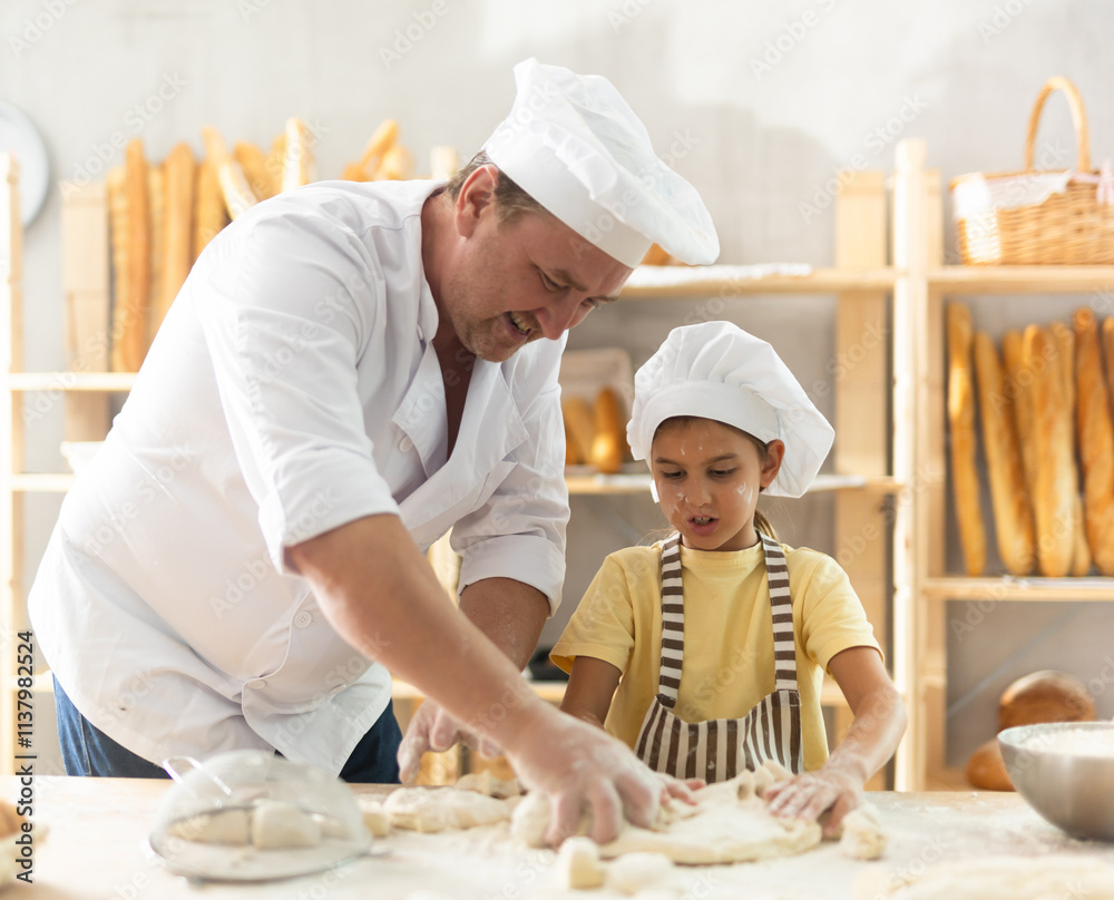 Father and daughter roll out dough together to make delicious bread Father and daughter roll out dough together to make delicious bread