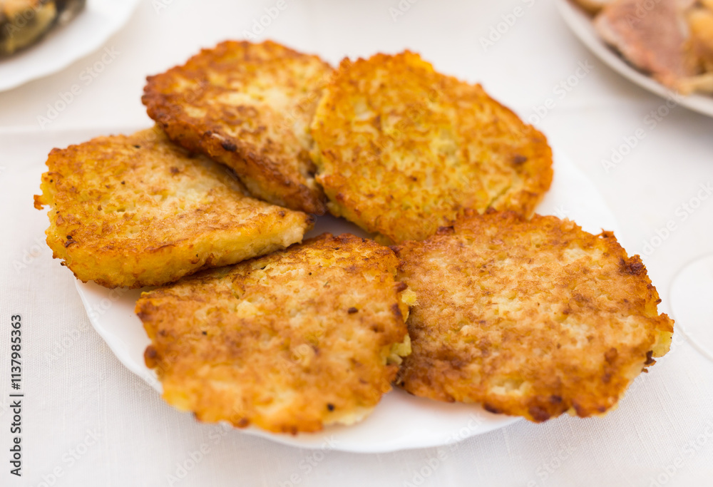 Potato pancakes with sour cream on white plate Potato pancakes with sour cream on white plate