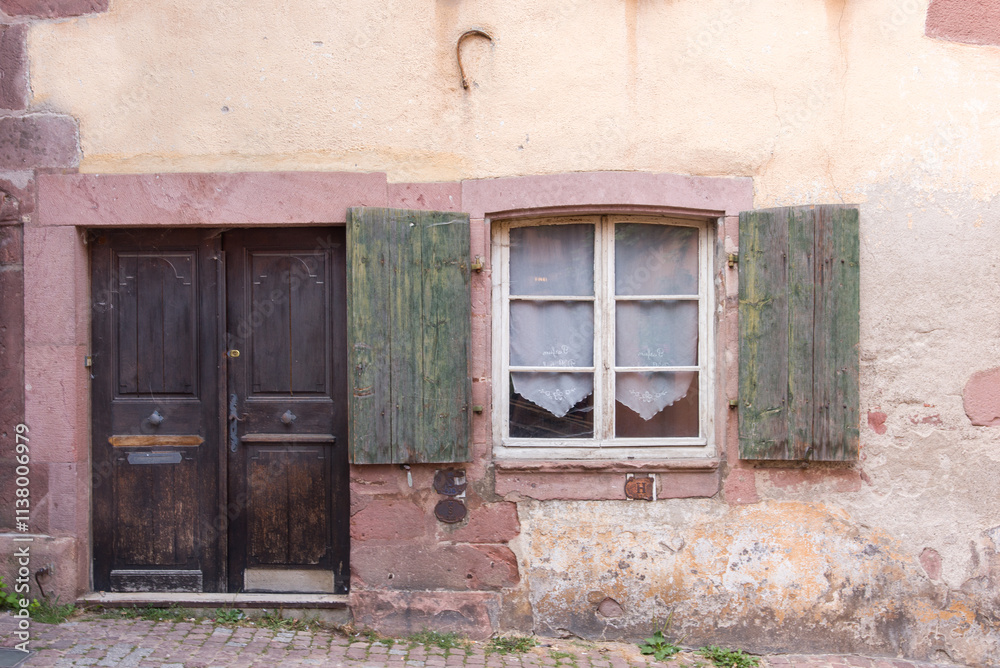 Façade d'une vieille maison alsacienne à Riquewihr. Ancienne maison avec une fenêtre et une porte en bois. Maison rustique. Alsace Façade d'une vieille maison alsacienne à Riquewihr. Ancienne maison avec une fenêtre et une porte en bois. Maison rustique. Alsace