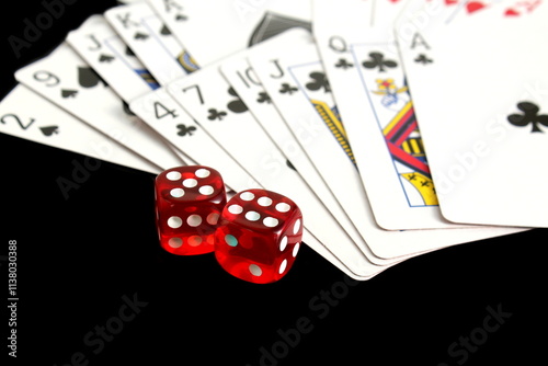 On a black background lies a deck of cards with dice.