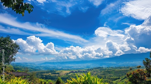 Scenic summer landscape with vibrant blue sky and fluffy white clouds over lush green hills in a tranquil natural setting