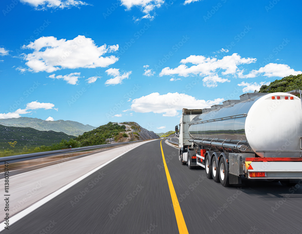 Fuel truck on a picturesque road. A silver tank truck transports fuel.