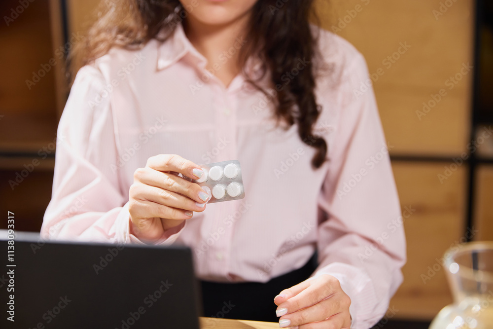 Cropped photo of young woman taking care of health. Female model sitting in office demonstrate pills blister. Concept of illness, healthy insurance, pharmaceutical, medicine. Ad.
