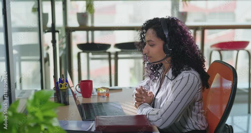 Indian young adult gen z curly hair woman lady sitting chair use laptop talk online video office place busy teen female girl expert staff look device screen speak share ideas do E work call centre job