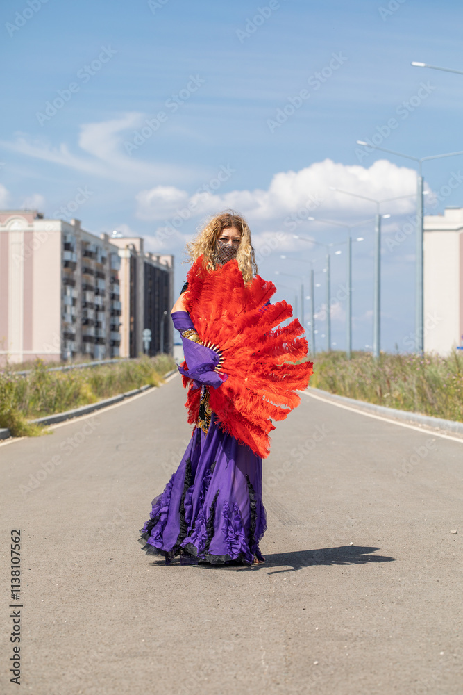 Naklejka premium Sexy beautiful woman in a purple costume dances on the street