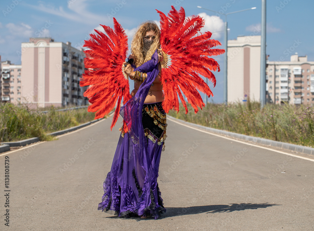 Naklejka premium Sexy beautiful woman in a purple costume dances on the street