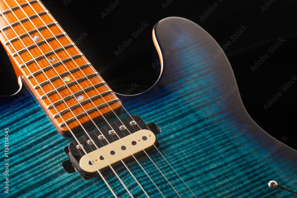 Detail of the neck, the pickup and the strings of a blue electric guitar Detail of the neck, the pickup and the strings of a blue electric guitar